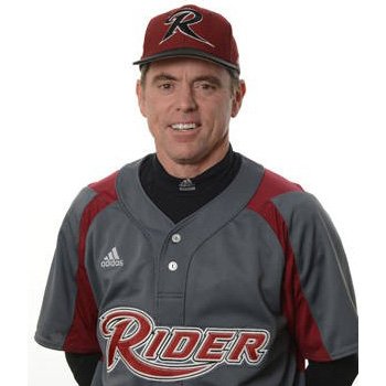 Coach Barry Davis smiles in his grey and maroon Rider Broncs uniform.
